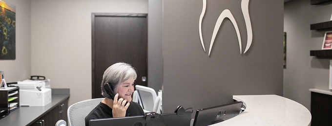 Receptionist taking dental appointment at Pauly Dental